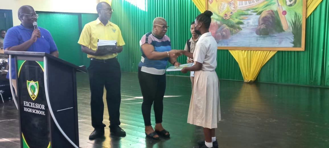 Ms.  Carol  Williams  representative  of Class of 1981 handing over the group's  check for payment of the Grade 9 Maths program workbooks.